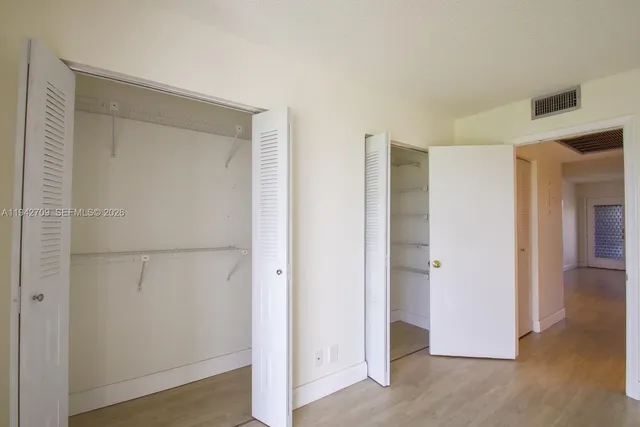 a view of walk in closet with wooden floor