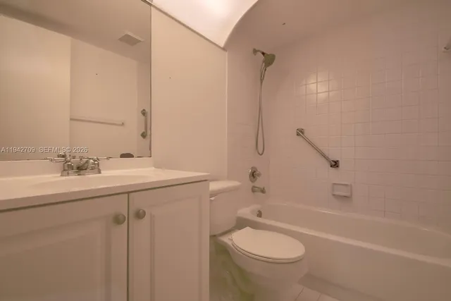 a bathroom with a granite countertop toilet sink and mirror