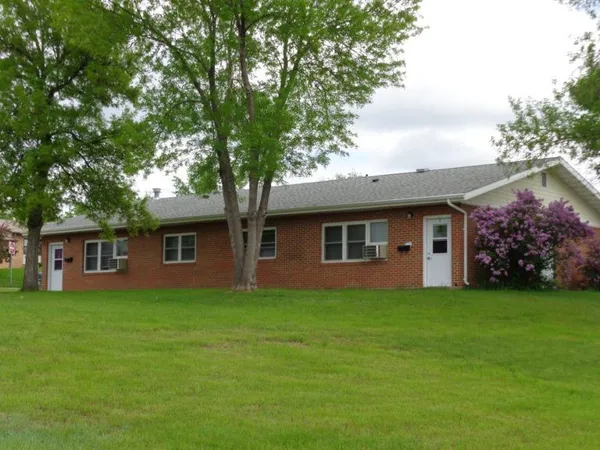 a front view of house with yard and trees