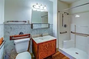 a bathroom with a sink a toilet and shower