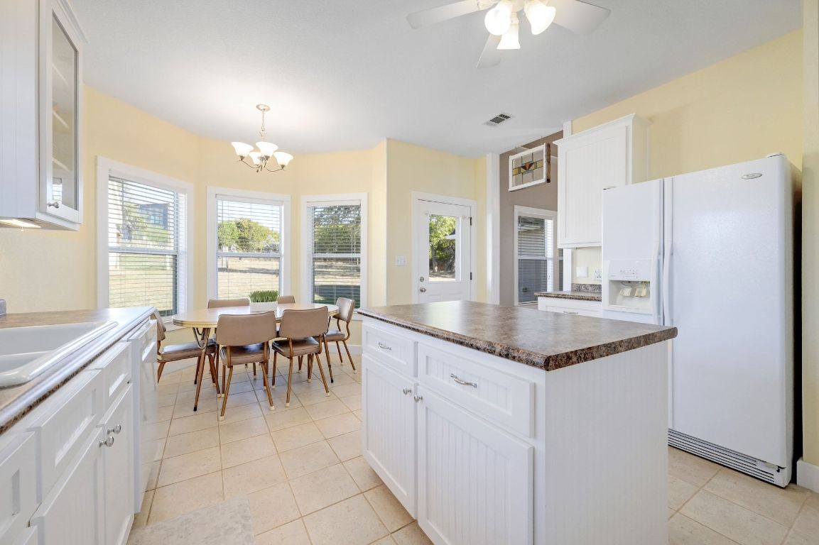 881 Saddle Ridge Drive Wimberley, TX 78676 - Photo 12 of 30 a kitchen with granite countertop cabinets and refrigerator