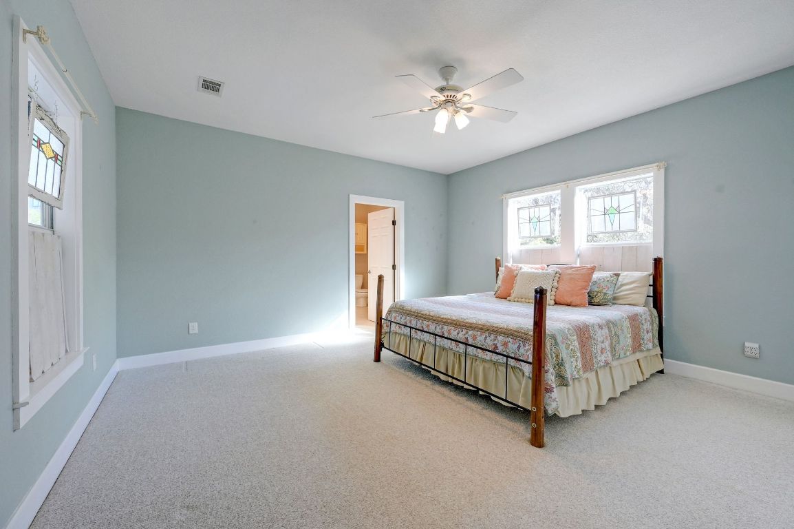 881 Saddle Ridge Drive Wimberley, TX 78676 - Photo 17 of 30 a bedroom with a large bed and a chandelier