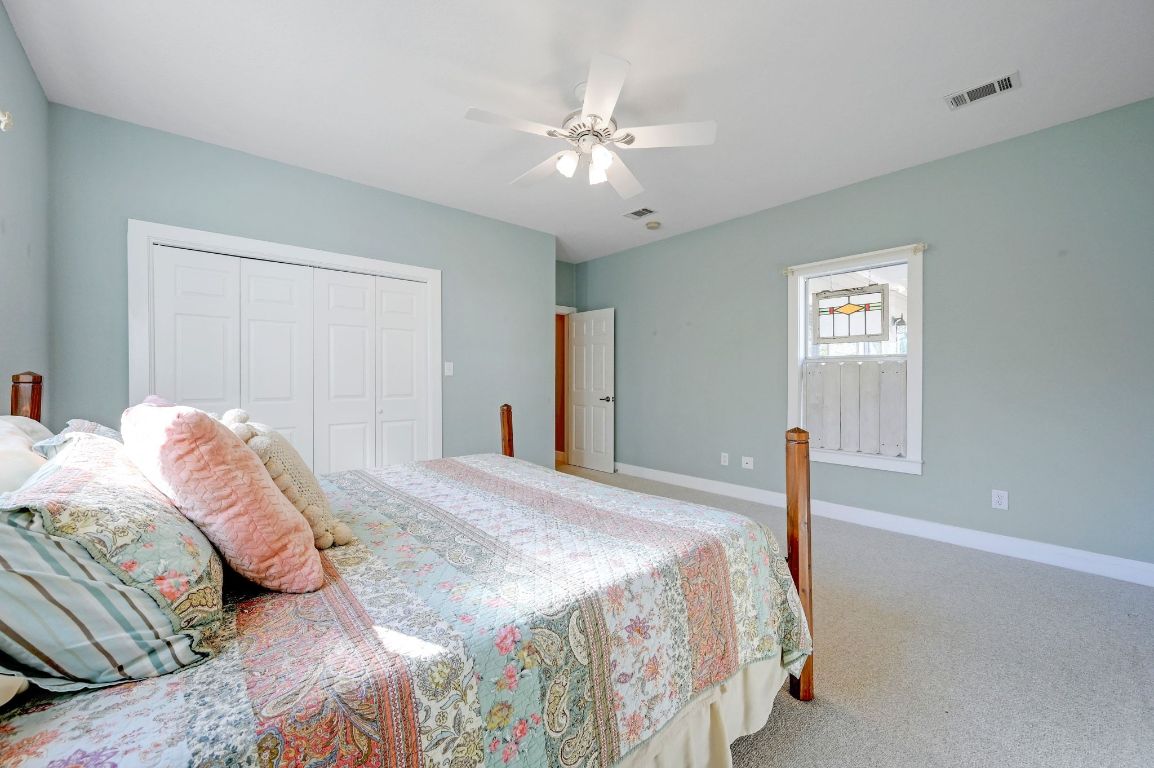 881 Saddle Ridge Drive Wimberley, TX 78676 - Photo 18 of 30 a bedroom with a large bed and a chandelier