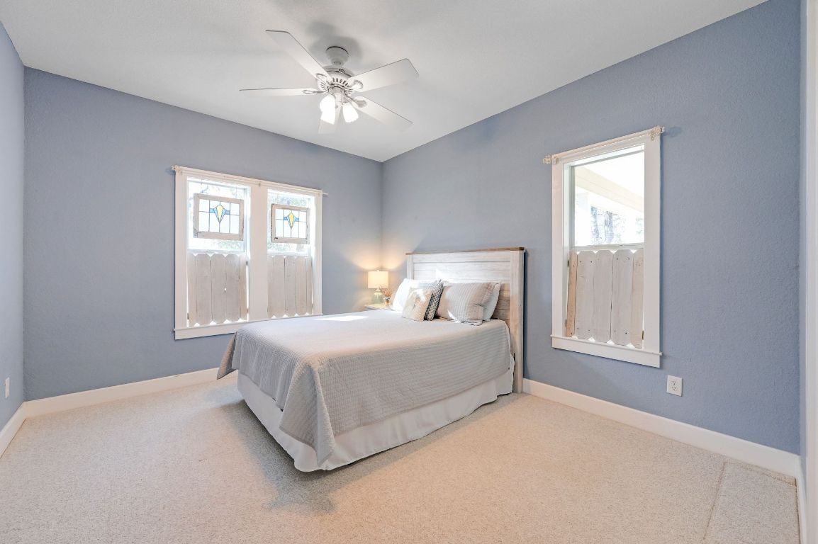 881 Saddle Ridge Drive Wimberley, TX 78676 - Photo 23 of 30 a spacious bedroom with a bed and a window