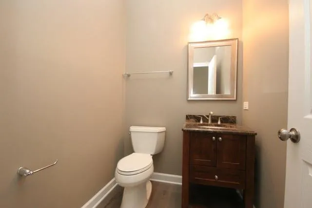 a bathroom with a toilet a sink and mirror