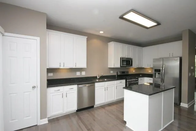 a kitchen with stainless steel appliances granite countertop a stove a sink and a refrigerator
