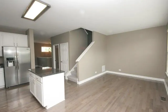 a kitchen with granite countertop a refrigerator and a sink