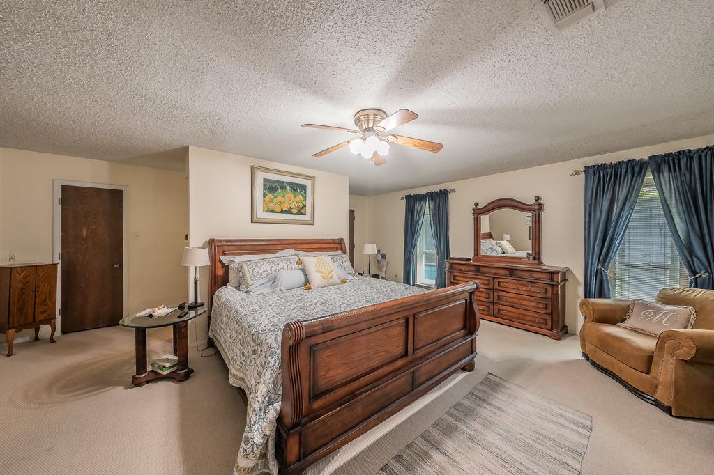2003 Edgebrook Court Arlington, TX 76015 - Photo 28 of 40 a bedroom with a large bed and a chandelier
