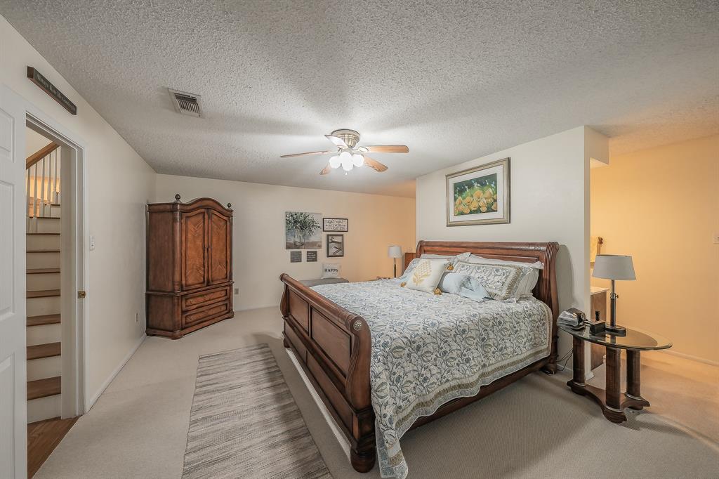 2003 Edgebrook Court Arlington, TX 76015 - Photo 31 of 40 a bedroom with a large bed and a chandelier