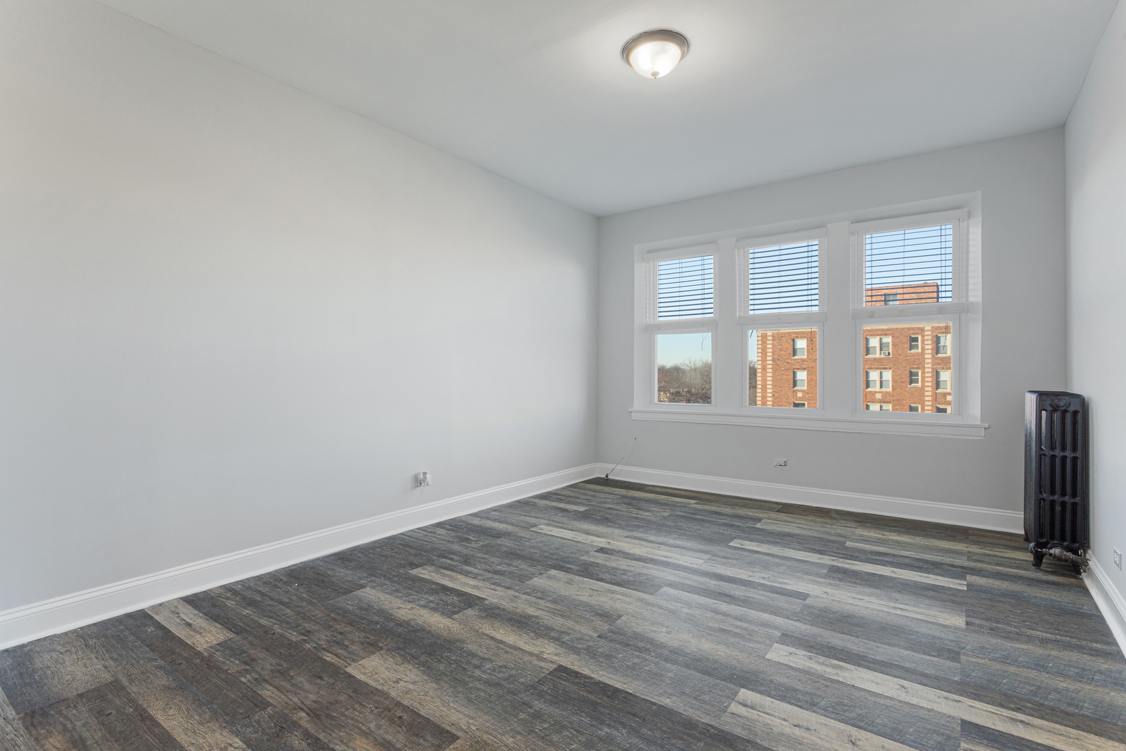 1608 West Sherwin Avenue, Unit 705 Chicago, IL 60626 - Photo 2 of 10 wooden floor in an empty room with a window