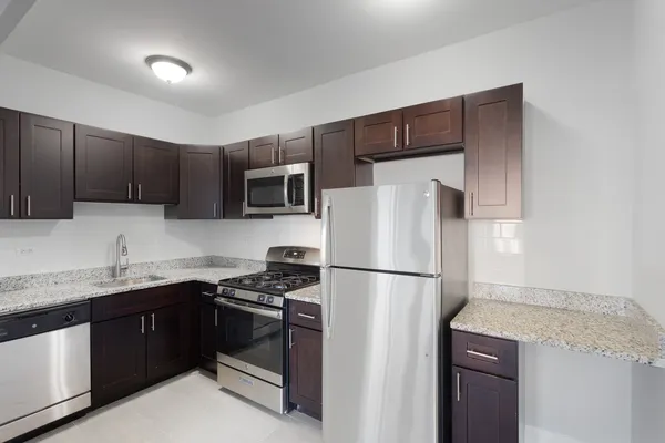 a kitchen with stainless steel appliances granite countertop a refrigerator stove a sink dishwasher and microwave