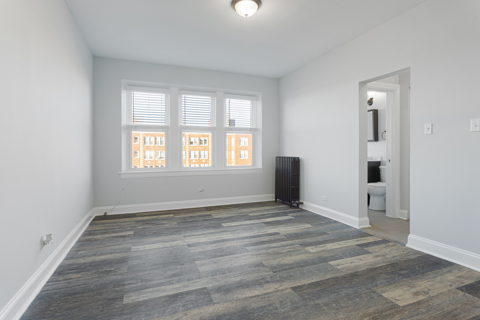 1608 West Sherwin Avenue, Unit 705 Chicago, IL 60626 - Photo 4 of 10 a view of an empty room with wooden floor and a window