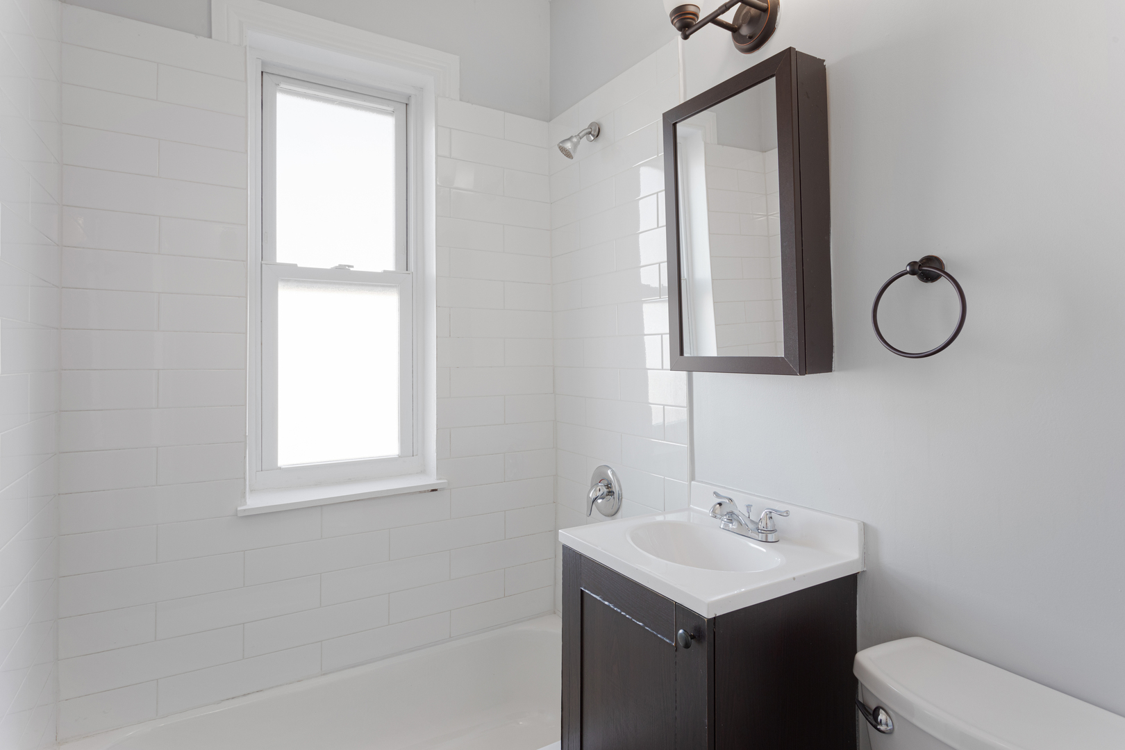 1608 West Sherwin Avenue, Unit 705 Chicago, IL 60626 - Photo 8 of 10 a bathroom with a sink a toilet and a mirror