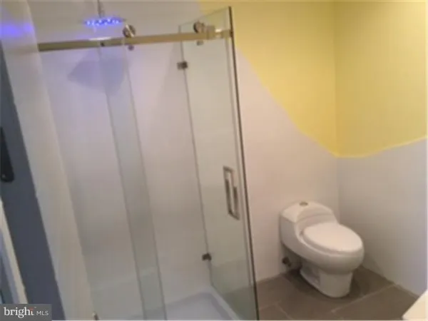 a white toilet sitting next to a shower