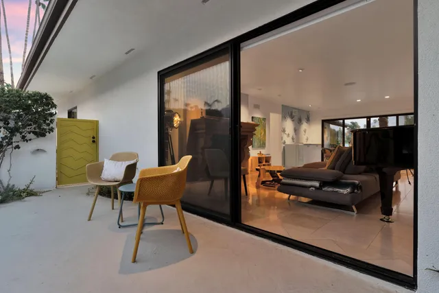 a view of a couches in the patio with a small yard