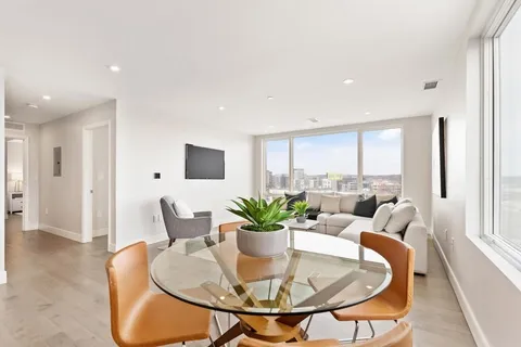 a dining room with furniture and a potted plant