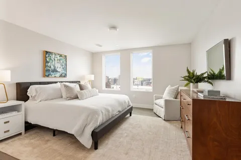 a bedroom with a large bed and a flat screen tv