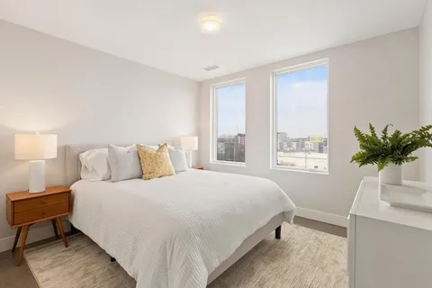 a bedroom with a bed table and a window