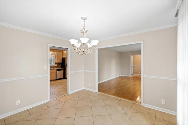 a view of a hallway with wooden floor windows and a living room