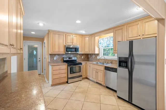a kitchen with granite countertop white cabinets and stainless steel appliances