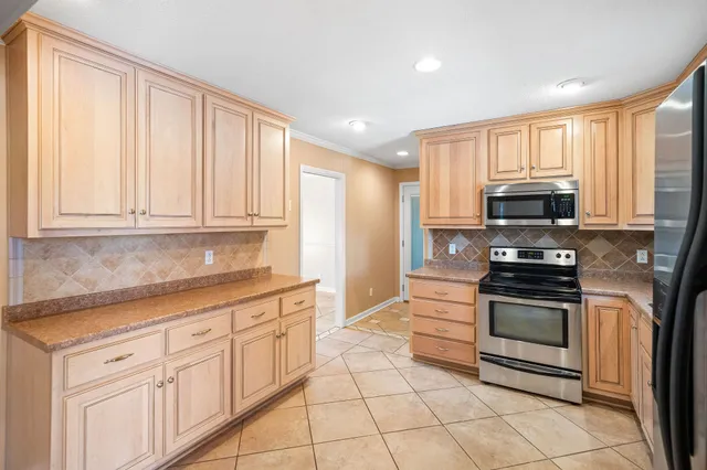 a kitchen that has a sink cabinets and stainless steel appliances