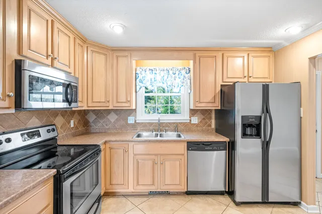 a kitchen with granite countertop white cabinets and a sink