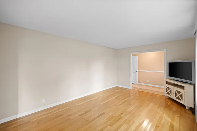 a view of a room with wooden floor and flat screen tv