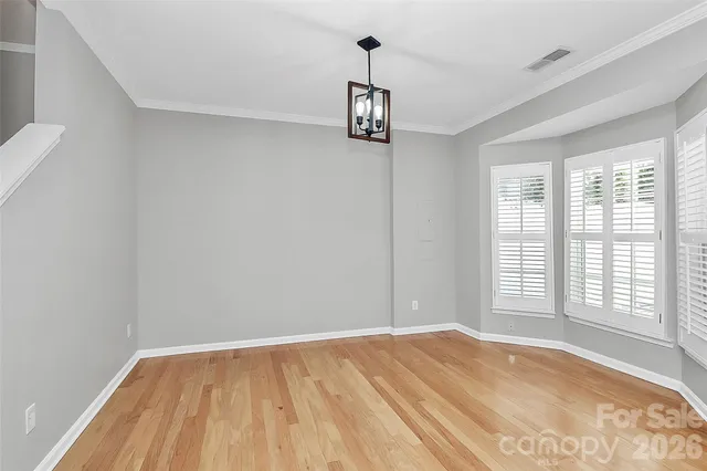 a kitchen with stainless steel appliances granite countertop a refrigerator a stove a sink dishwasher a dining table and chairs with wooden floor