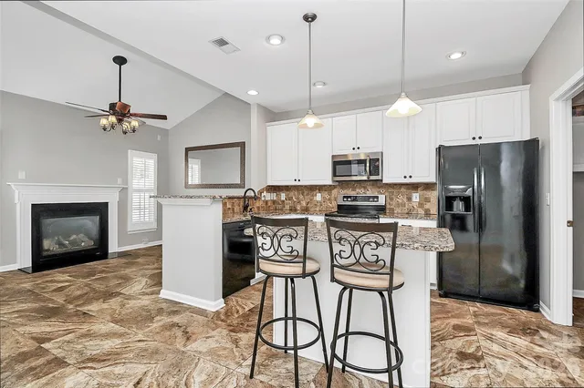 a kitchen with stainless steel appliances granite countertop a stove microwave and cabinets