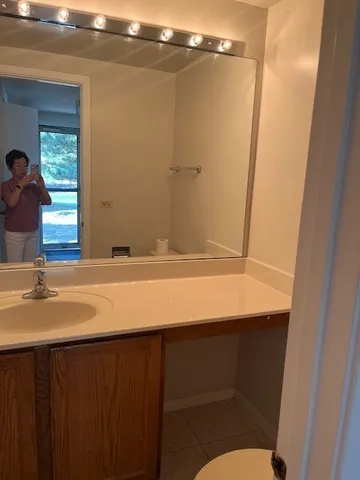 a bathroom with a sink a toilet a mirror and shower
