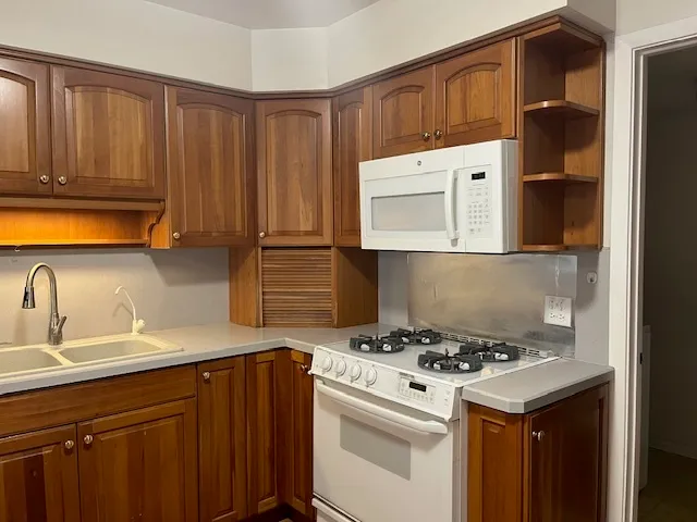 a kitchen with a sink a stove and cabinets
