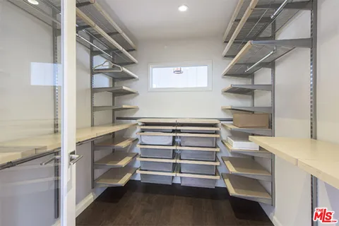 a view of walk in closet with empty racks