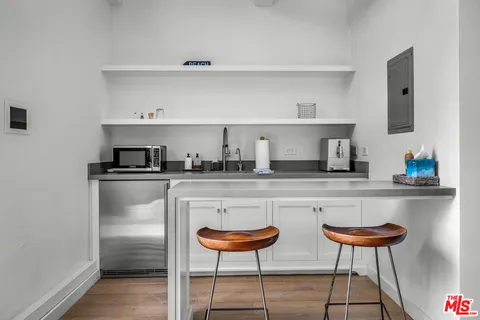 a kitchen with stainless steel appliances a dining table chairs and a refrigerator
