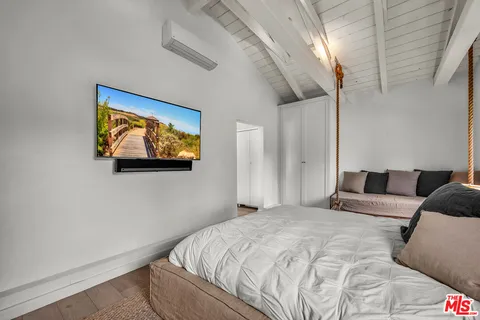 a bedroom with a bed and a painting on the wall
