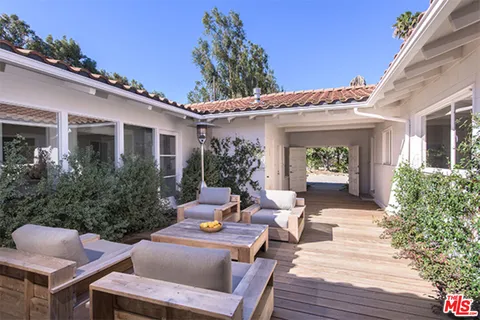 a view of a patio with couches table and chairs and potted plants