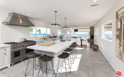 a kitchen with stainless steel appliances a stove a sink refrigerator and a wooden cabinets