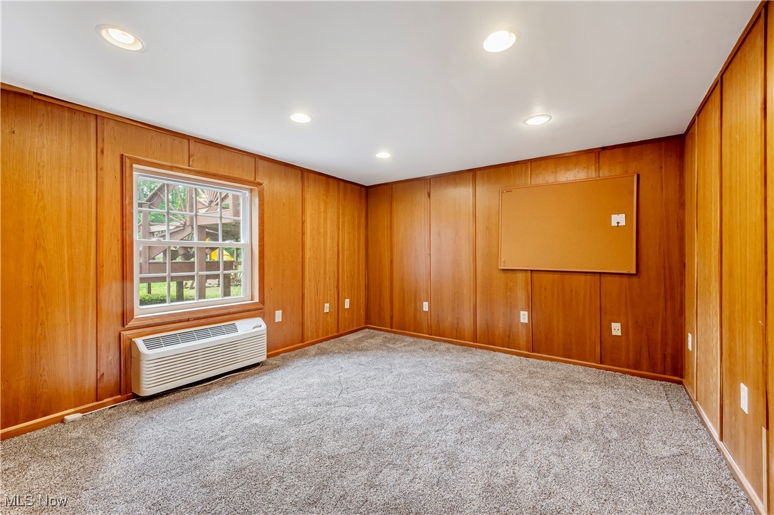12358 Harmon Road New Springfield, OH 44443 - Photo 35 of 44 Empty room featuring recessed lighting, light carpet, wood walls, and a wall mounted air conditioner