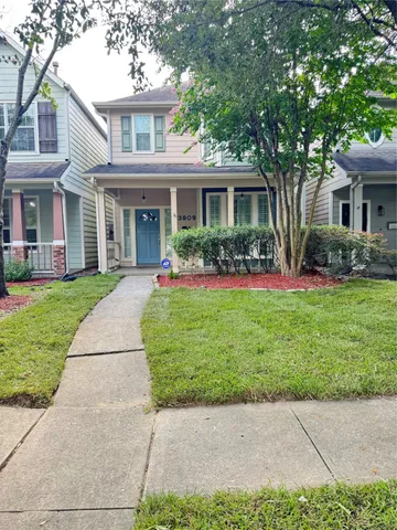 front view of a brick house with a yard