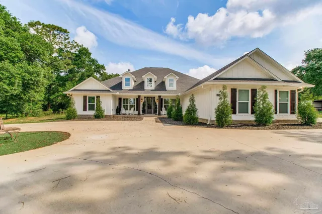 a front view of a house with a yard and potted plants