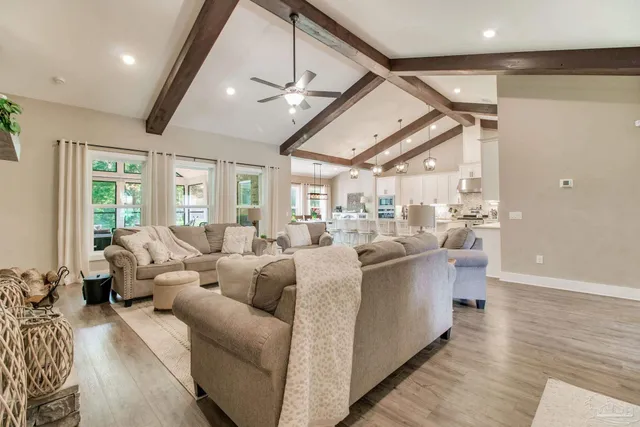 a kitchen with stainless steel appliances kitchen island granite countertop a dining table chairs and white cabinets