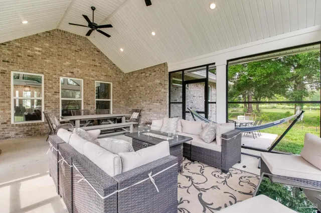 a kitchen with stainless steel appliances a dining table chairs refrigerator and cabinets