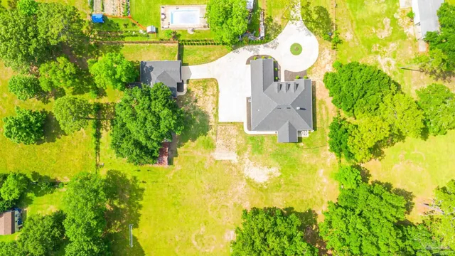an aerial view of residential houses with outdoor space and trees