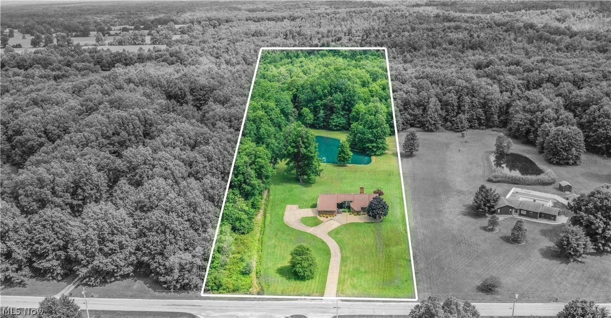 405 Airport Road Northwest Warren, OH 44481 - Photo 50 of 50 Expansive acreage featuring a ranch with a brick exterior, a paved driveway, lush green lawns, mature trees, and a private pond