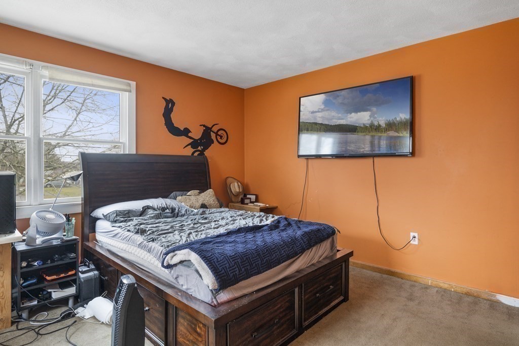 45 Burley Street Danvers, MA 01923 - Photo 30 of 41 a bedroom with a bed and paintings on the wall