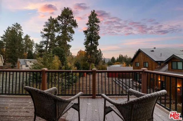 a view of a balcony with wooden floor and outdoor seating