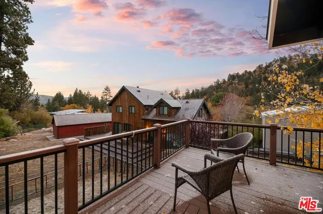 a view of a balcony with wooden floor and outdoor seating