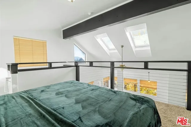 a balcony with table and chairs and potted plants