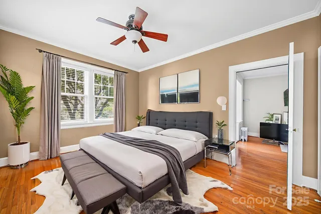 a bedroom with a bed a chandelier and a couch
