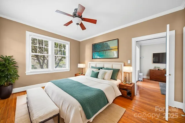 a bedroom with a large bed a chandelier and a couch