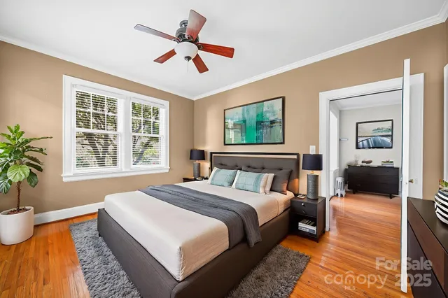 a bedroom with a large bed a chandelier and windows